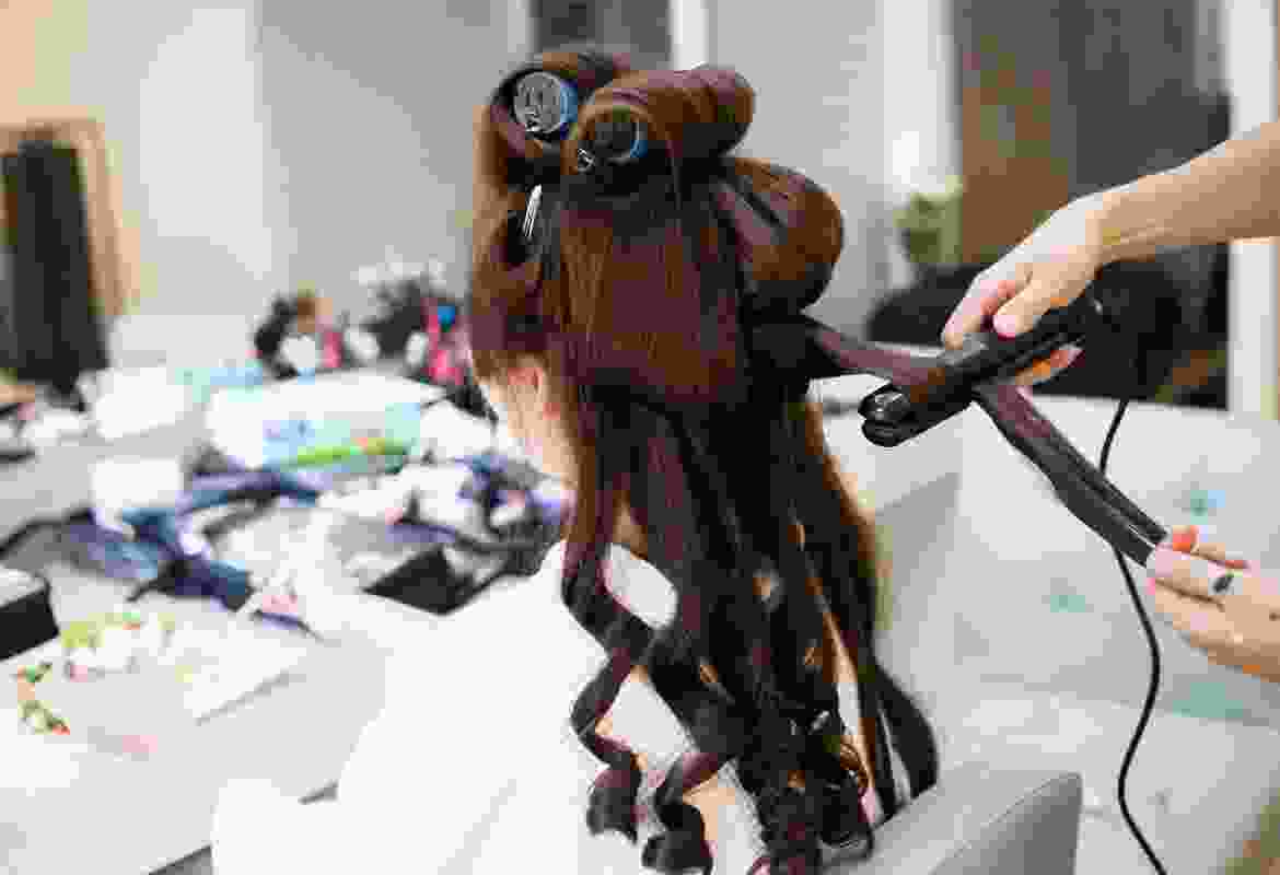 A person holding a hair dryer and brush.