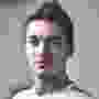 A man with pink and white face is pixelated.