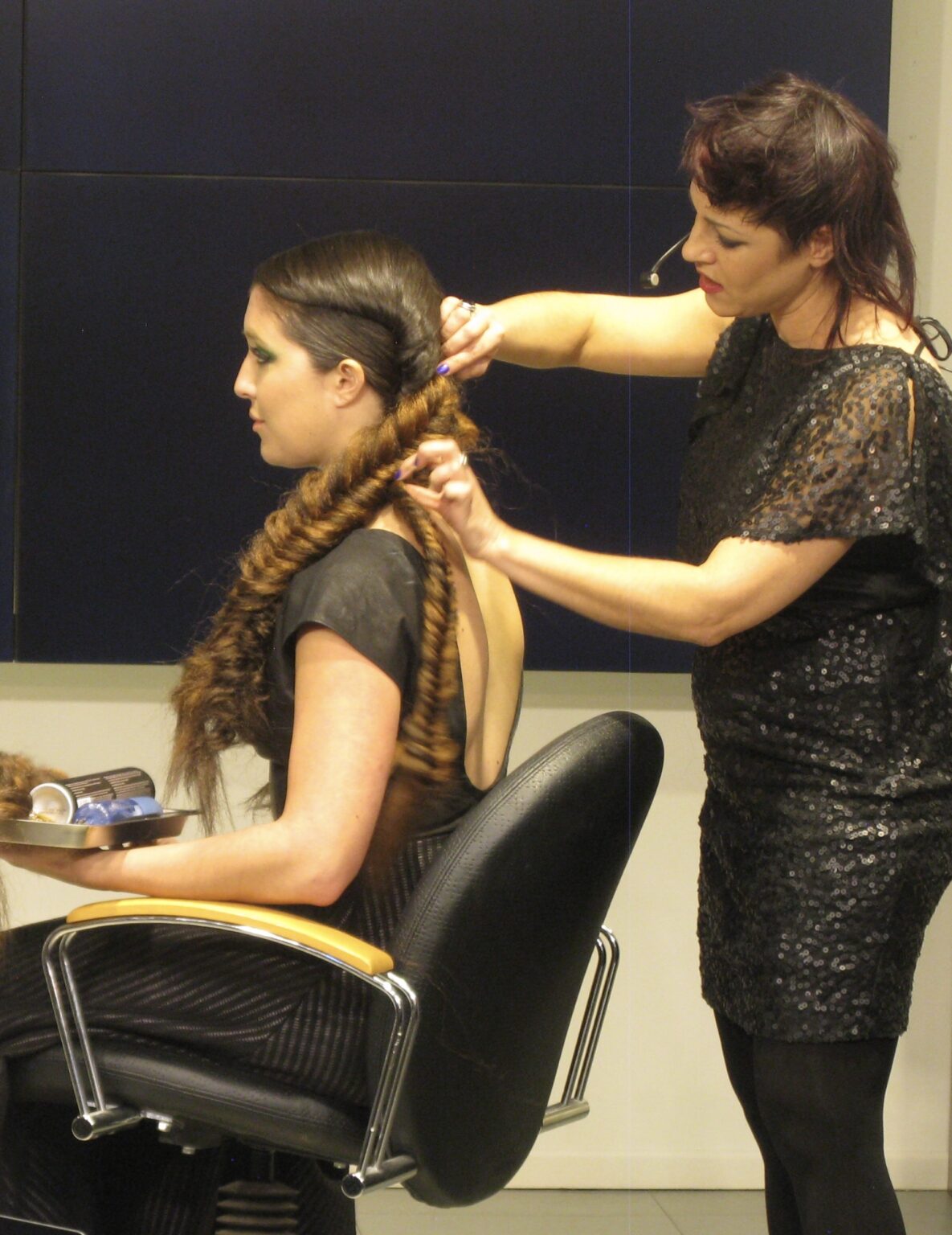 Woman getting her hair braided by stylist.